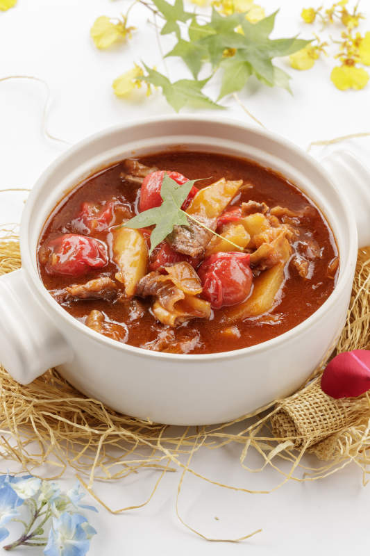 白色砂锅装的番茄土豆炖牛腩图片