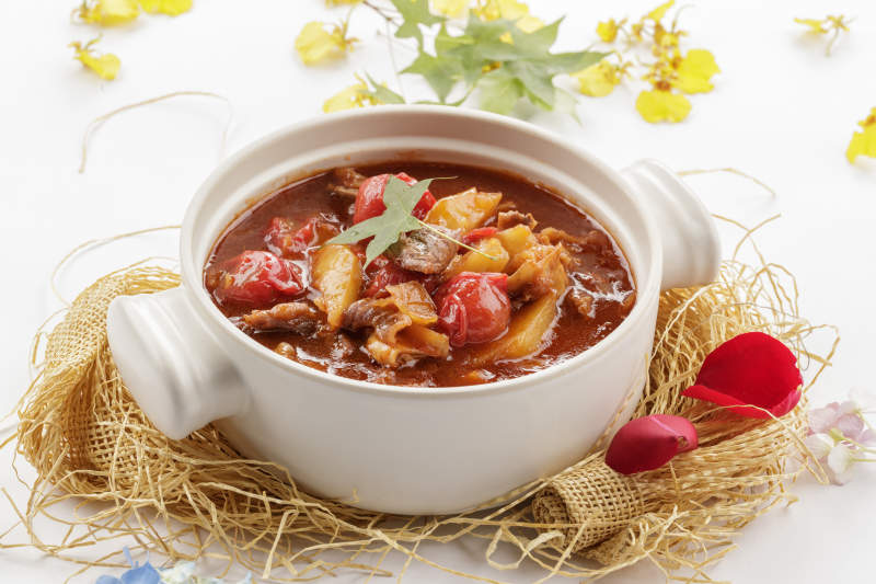 白色砂锅装的番茄土豆炖牛腩图片