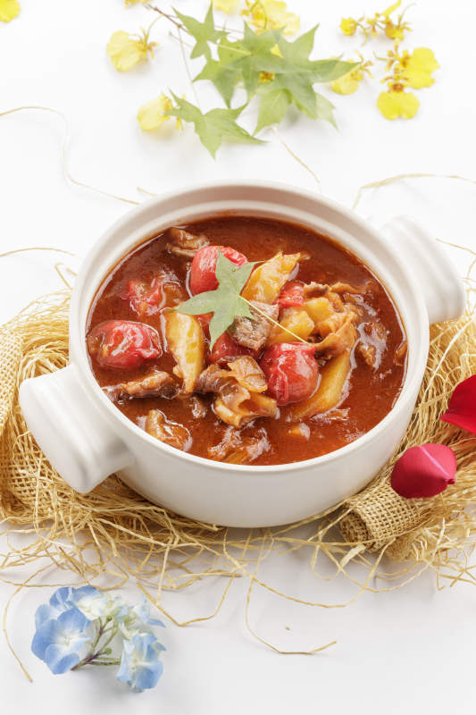 白色砂锅装的番茄土豆炖牛腩图片