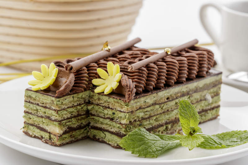 巧克力酱抹茶奶酪慕斯蛋糕摆放在白色背景上图片