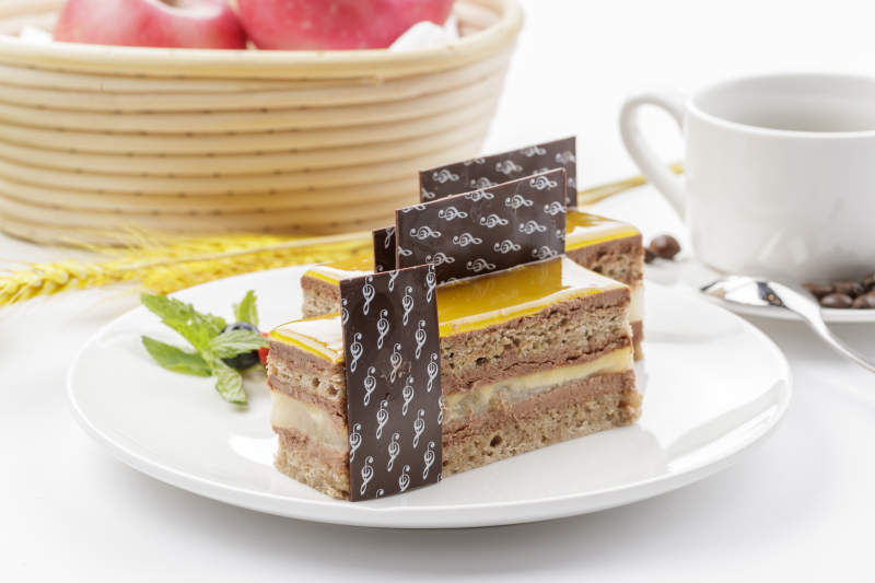 果酱杏仁慕斯蛋糕摆放在白色背景上图片