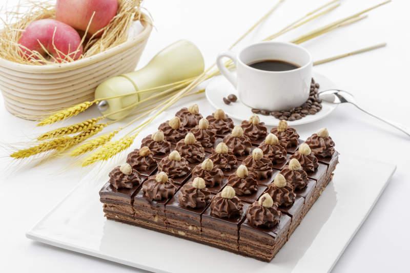 圆形黑色石板装的甜品全拼摆放在黑色背景上图片