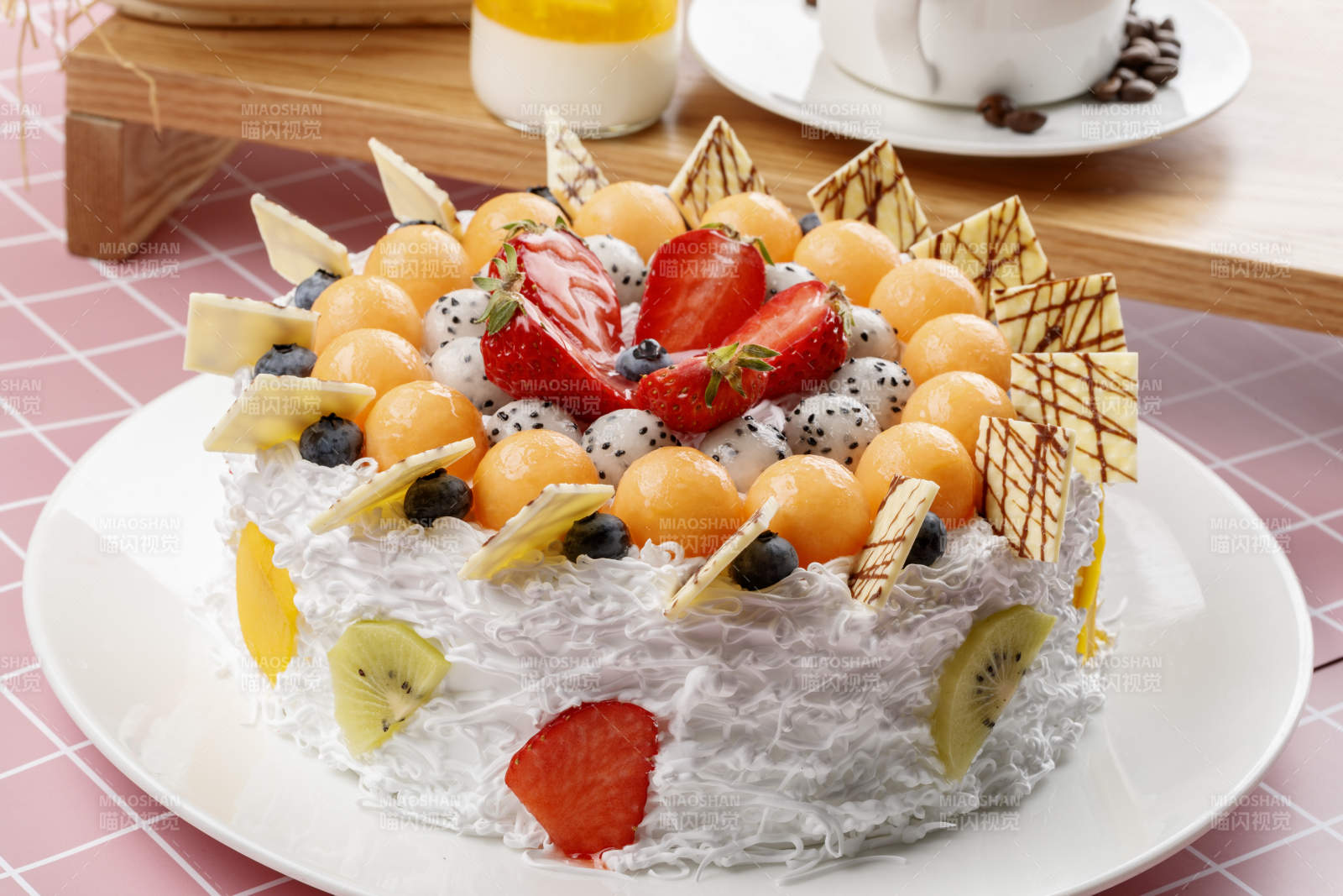 奶油缤纷水果蛋糕摆放在粉色背景上图片