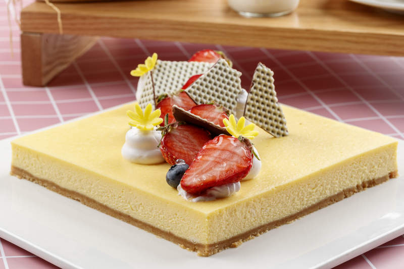 奶油缤纷水果蛋糕摆放在粉色背景上图片