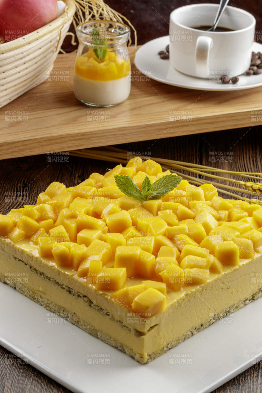 芒果奶油三层蛋糕摆放在木纹底板上图片