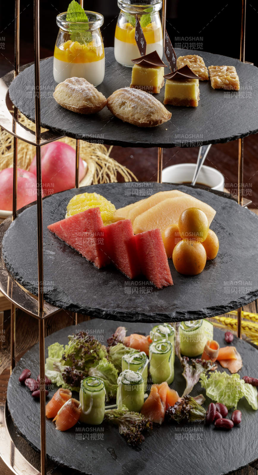 芒果奶油三层蛋糕摆放在木纹底板上图片