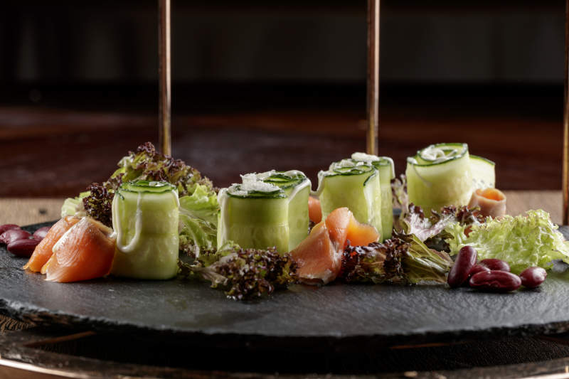 圆形黑色石板装的甜品全拼摆放在黑色背景上图片