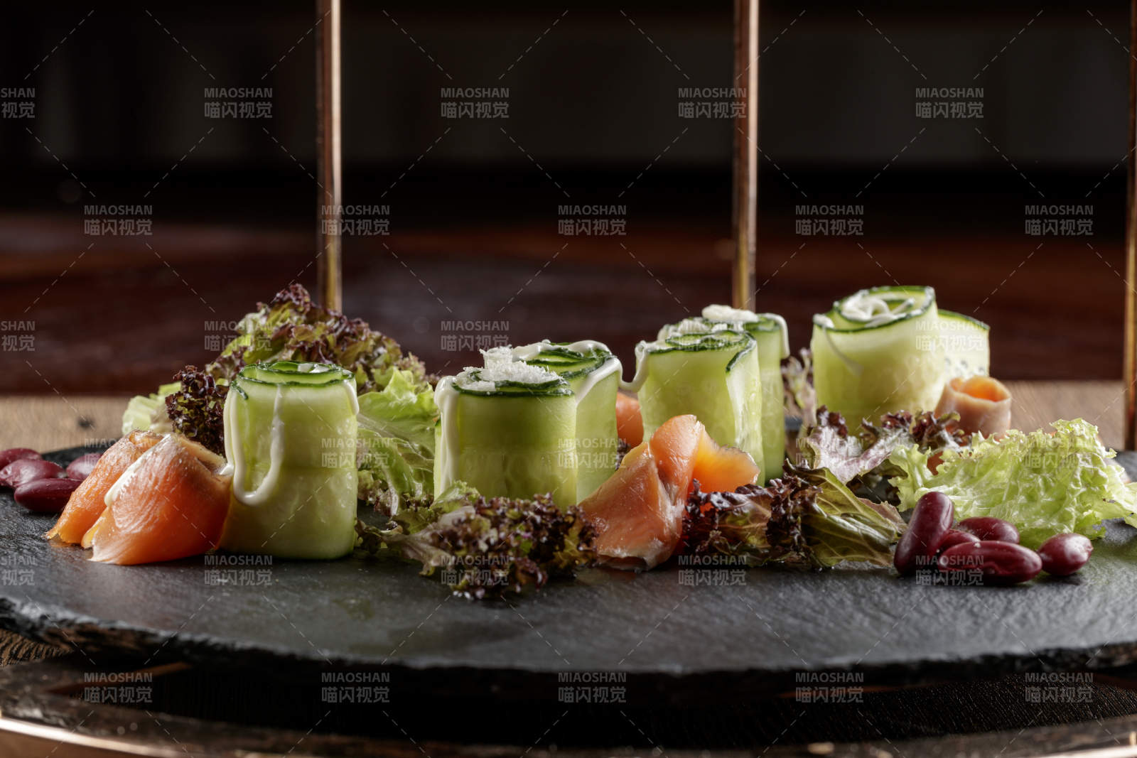 圆形黑色石板装的甜品全拼摆放在黑色背景上图片