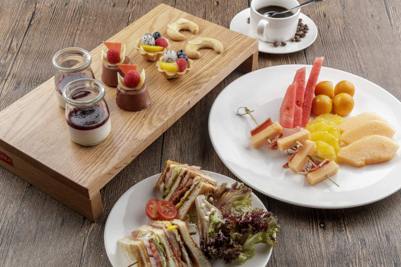 圆形黑色石板装的甜品全拼摆放在黑色背景上图片