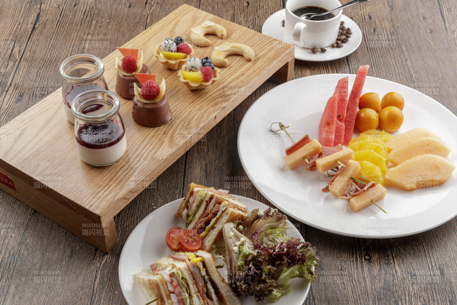 圆形黑色石板装的甜品全拼摆放在黑色背景上图片