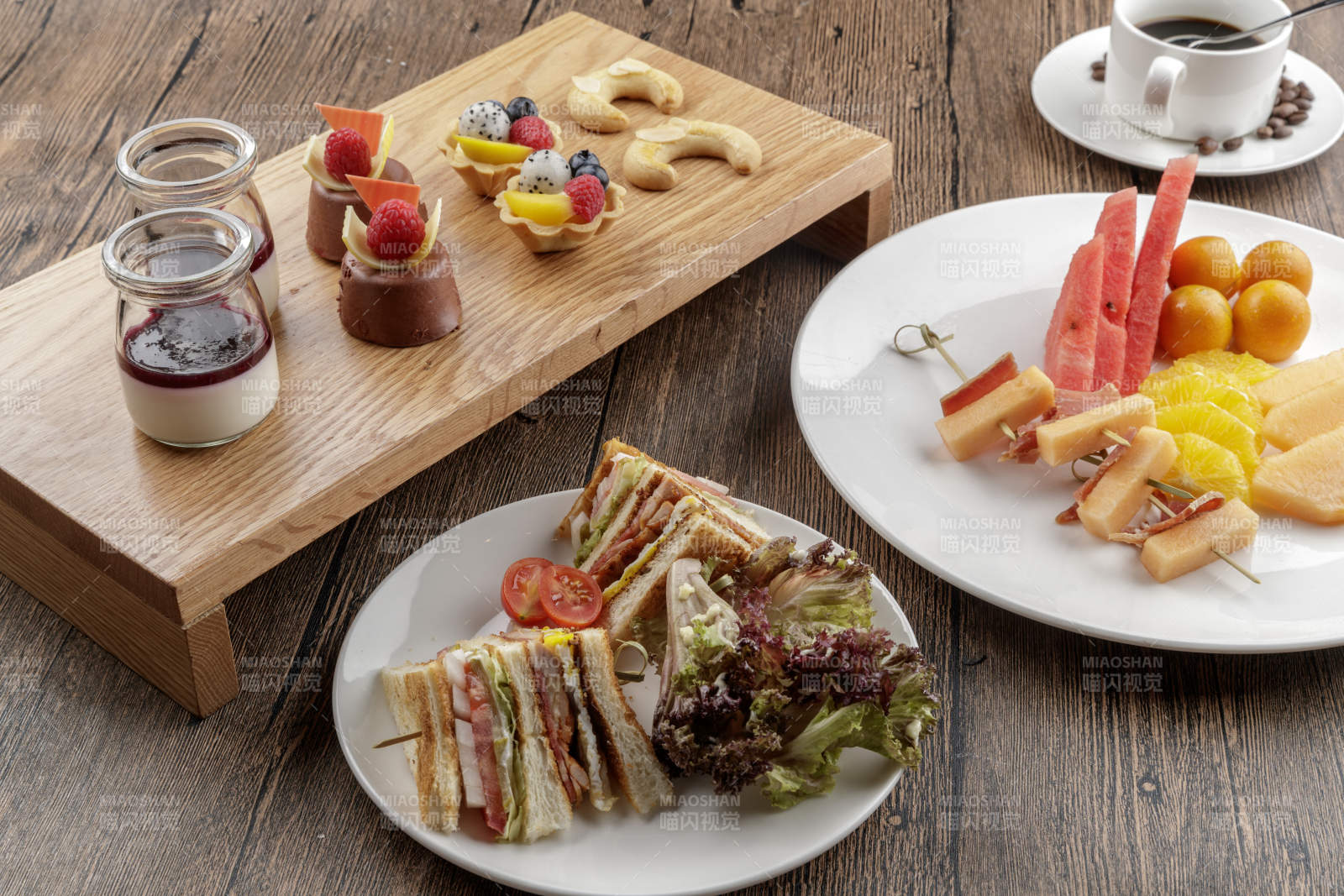 圆形黑色石板装的甜品全拼摆放在黑色背景上图片