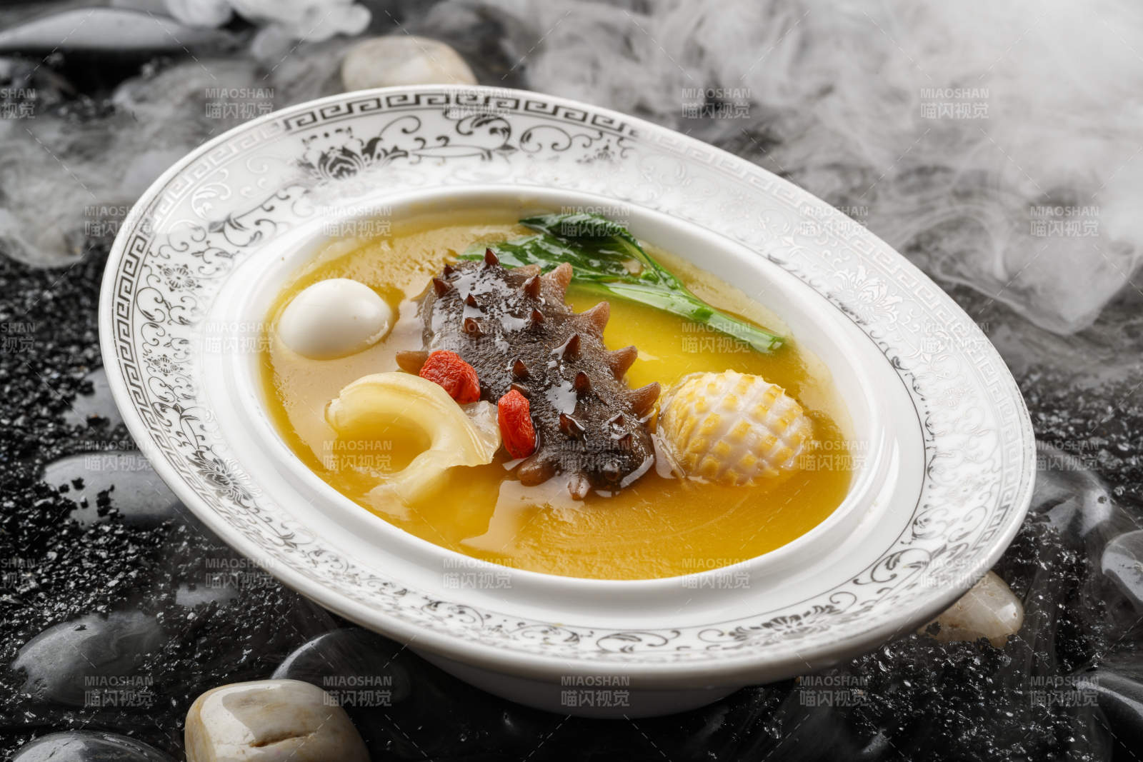 小米炖辽参摆放在黑色鹅卵石上图片