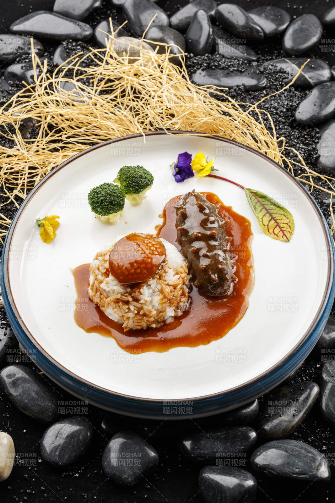 鲜鲍鱼辽参捞饭摆放在黑色鹅卵石上图片