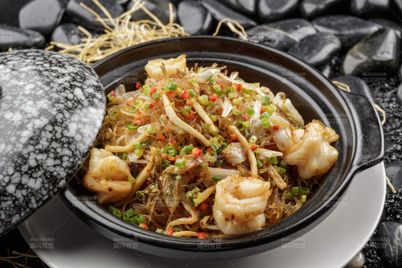干捞海皇粉丝煲摆放在黑色鹅卵石上图片