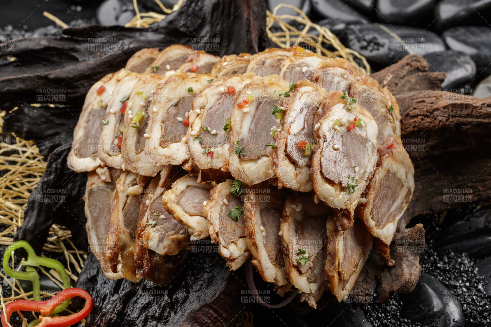 崖柏根装的蒙古烤羊里脊摆放在黑色鹅卵石上图片