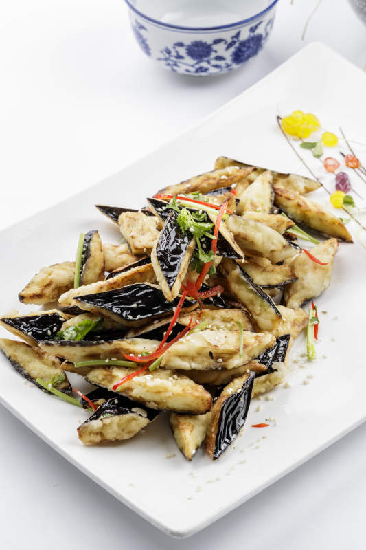 白色瓷盘装的油炸复合味茄子图片