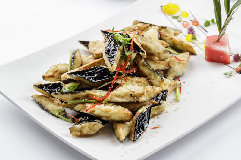 白色瓷盘装的油炸复合味茄子图片