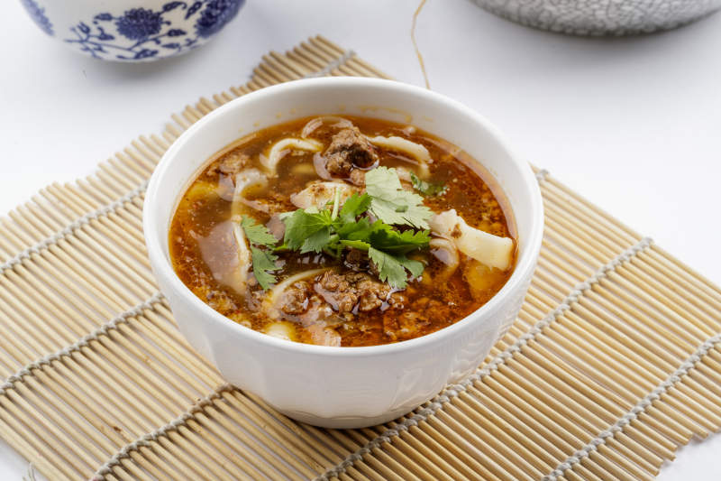 老大同肉末刀削面摆放在寿司帘上图片