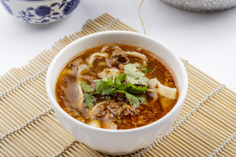 老大同肉末刀削面摆放在寿司帘上图片