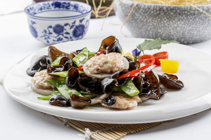 白色圆盘装的荷塘脆玉藕醸摆放在寿司帘上图片