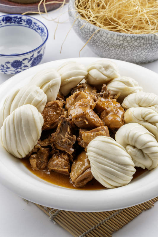 锅烧柴鸡小花卷摆放在白色背景上图片