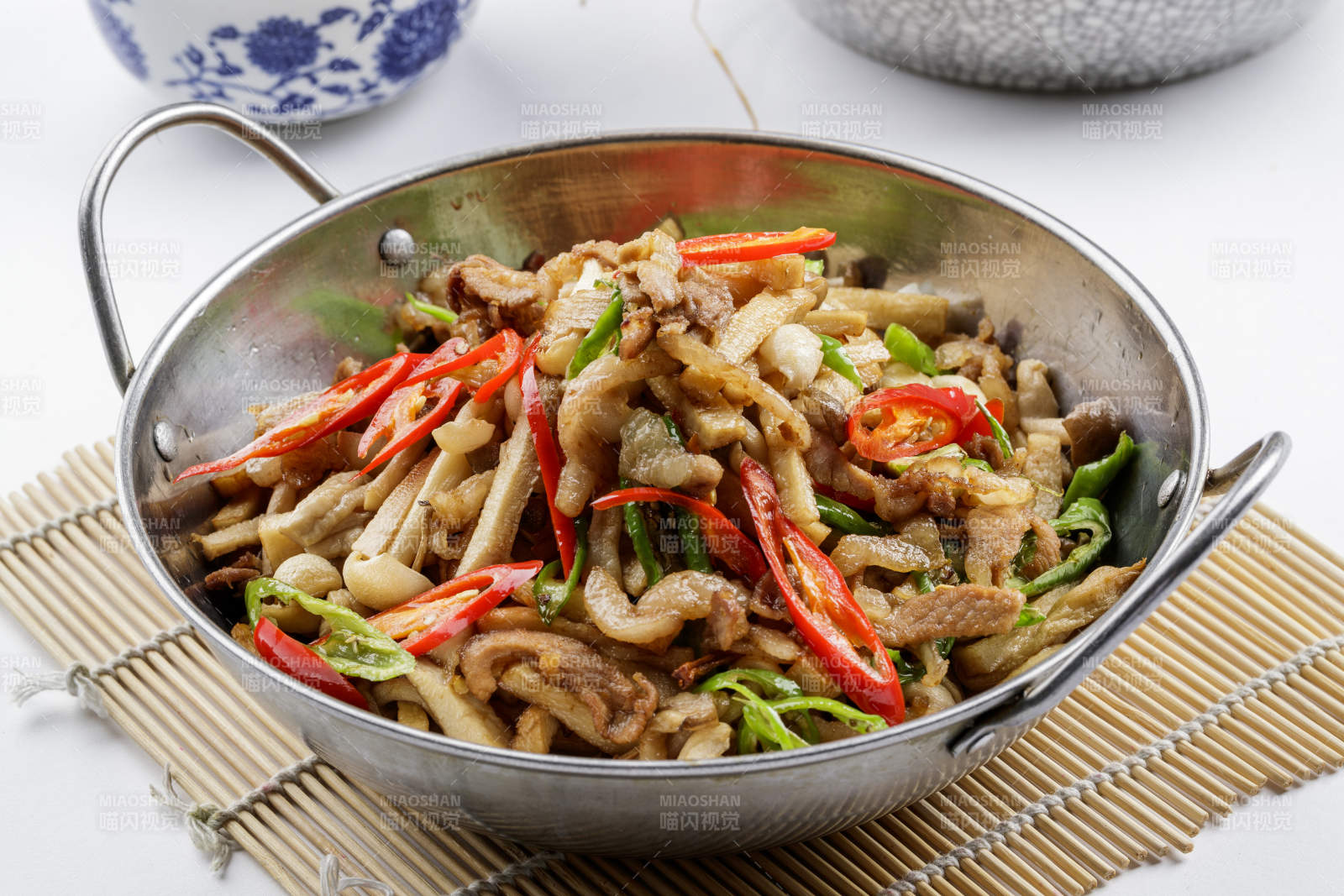 铁锅装的干锅山珍菌摆放在寿司帘上图片