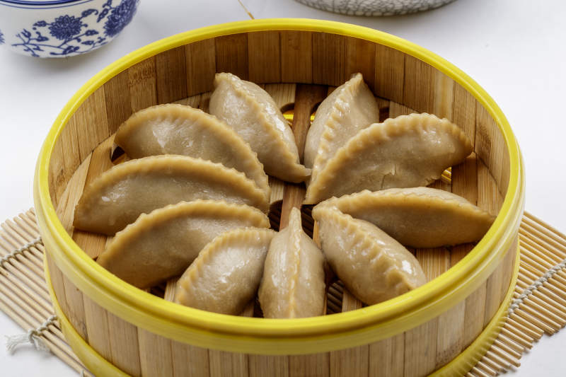 热腾腾的莜面蒸饺摆放在白色背景上图片