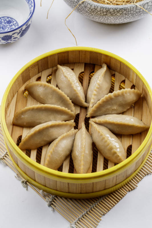 热腾腾的莜面蒸饺摆放在白色背景上图片