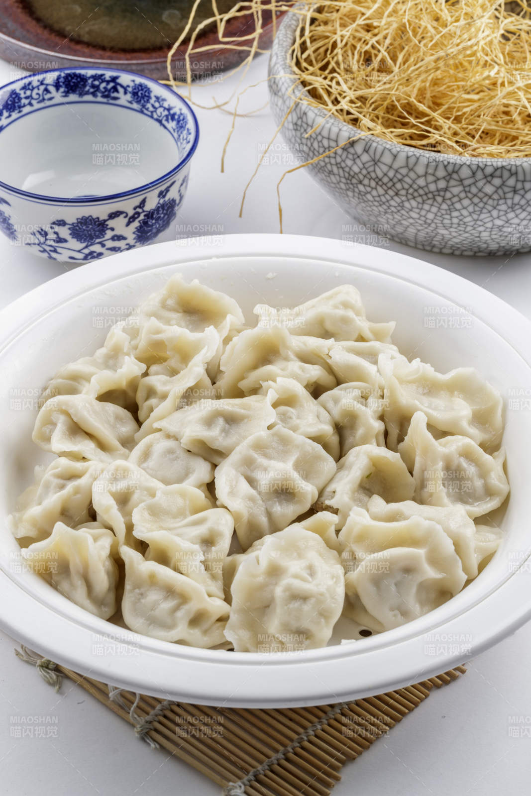 刚出锅的猪肉大葱饺子摆放在白色背景上图片