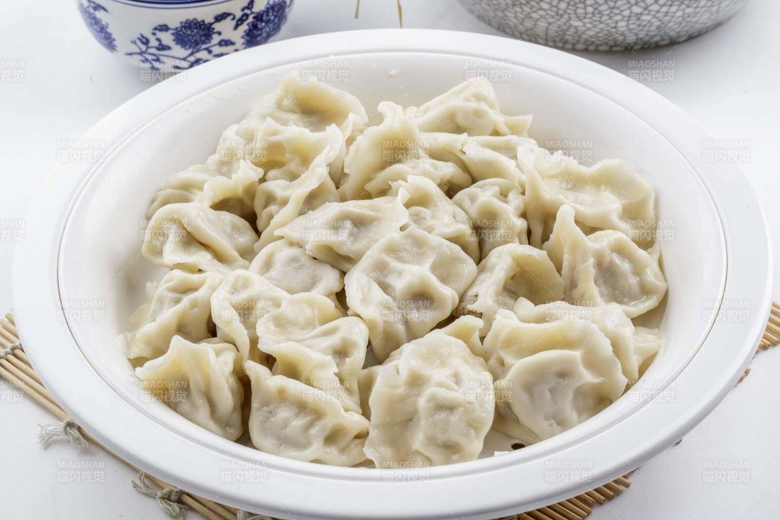 刚出锅的猪肉大葱饺子摆放在白色背景上图片