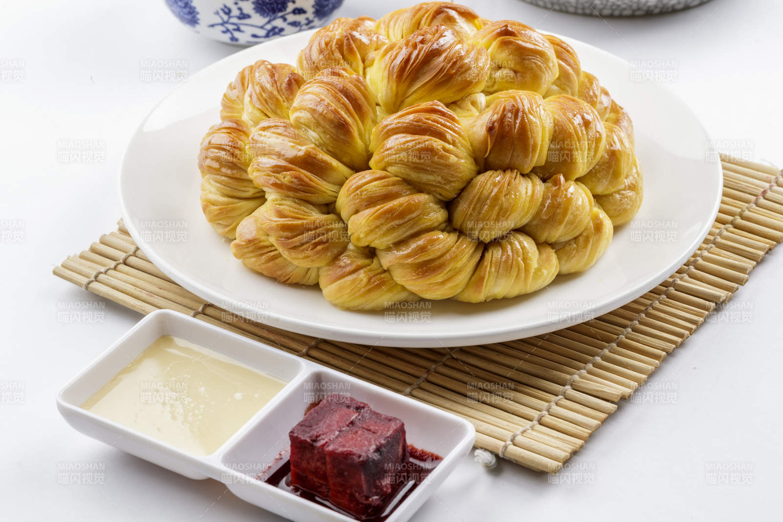 白色圆形瓷盘装的麻油大花卷图片