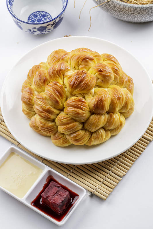 白色圆形瓷盘装的麻油大花卷图片