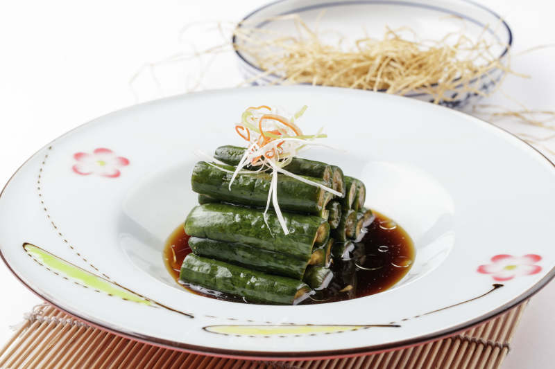 白色瓷盘装的老醋腌渍黄瓜段图片