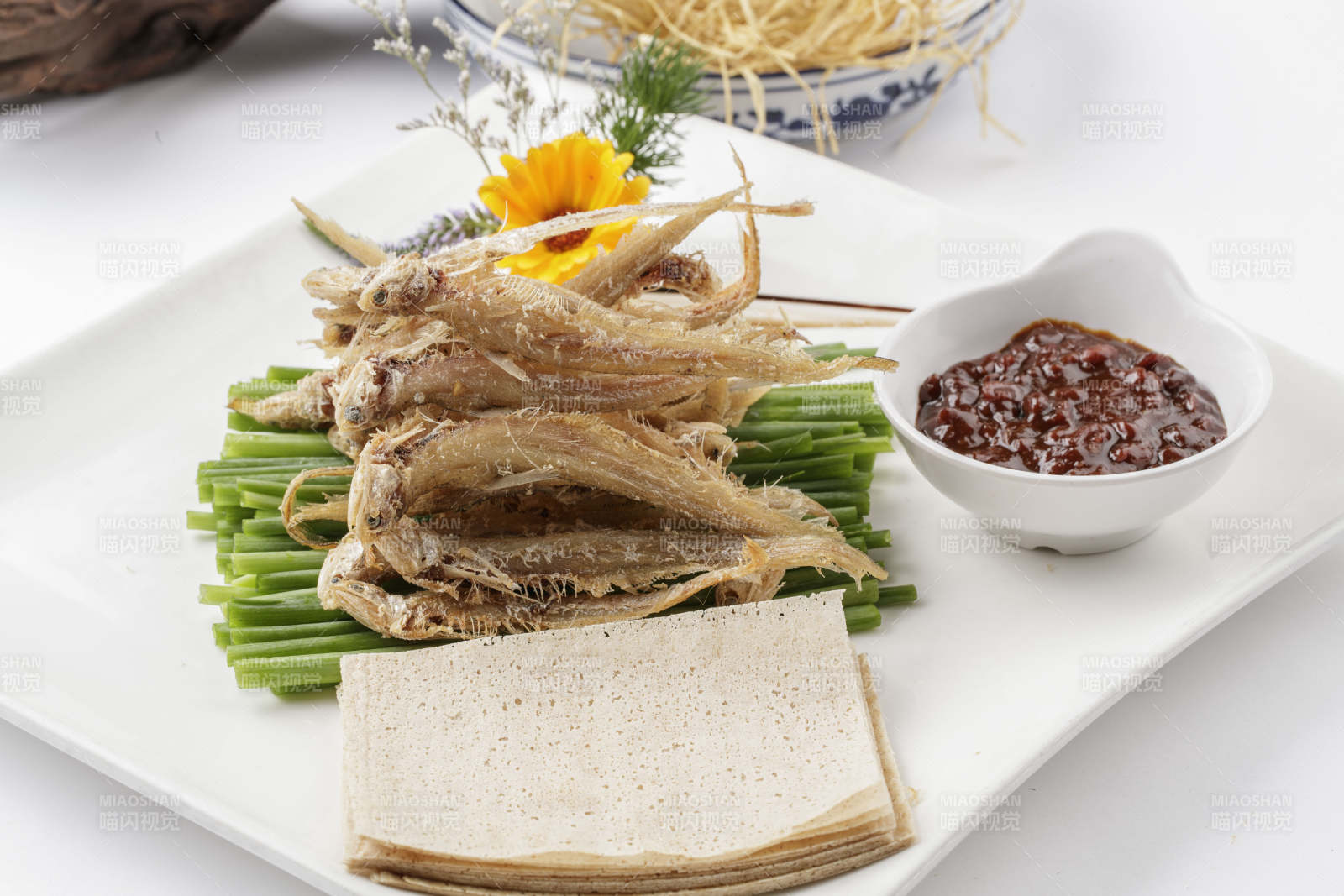 白色瓷盘装的煎饼皮卷干炸银鱼图片
