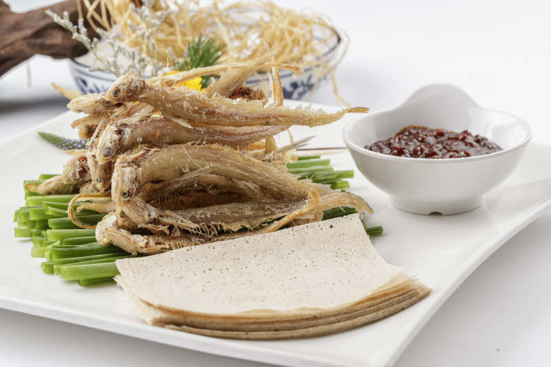 白色瓷盘装的煎饼皮卷干炸银鱼图片