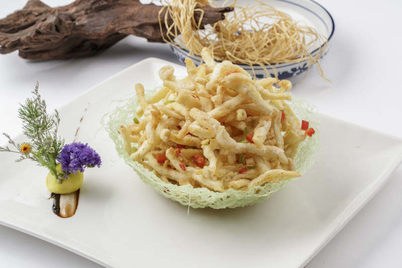 白色背景上的方瓷盘装的香炸海鲜蘑菇图片