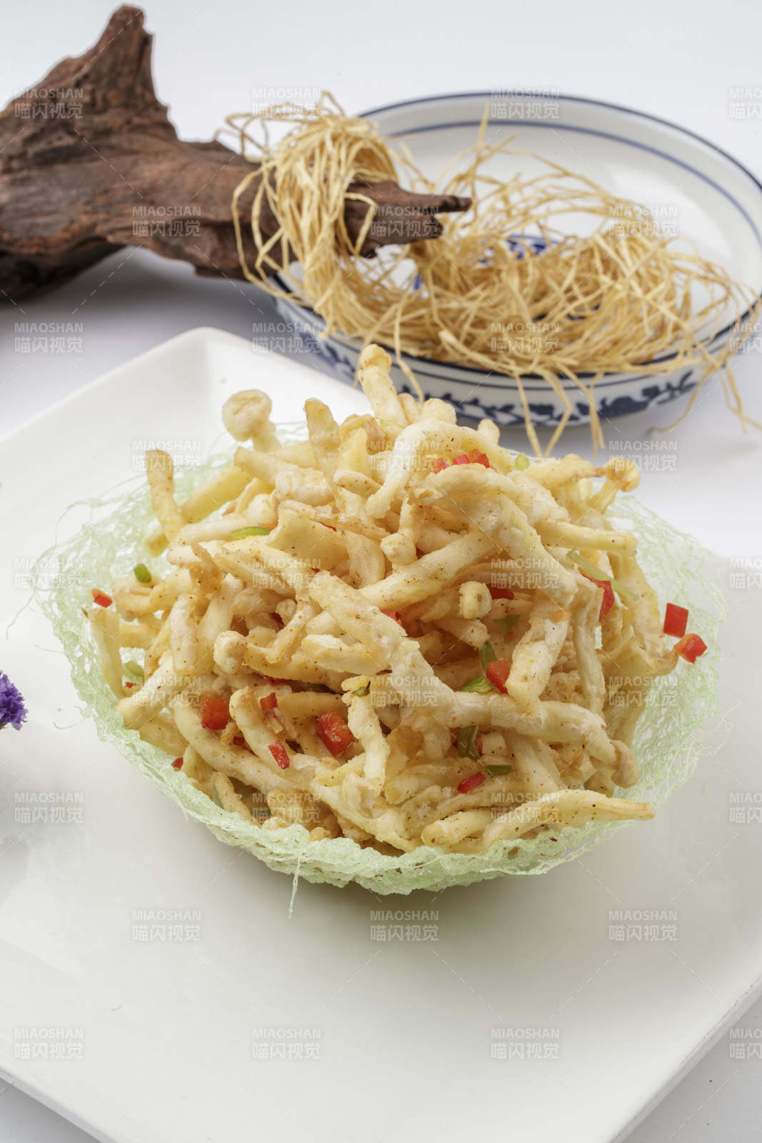 白色背景上的方瓷盘装的香炸海鲜蘑菇图片