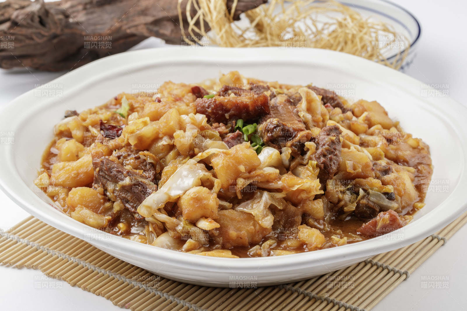 寿司帘上的环纹瓷盘装的一品乱炖图片