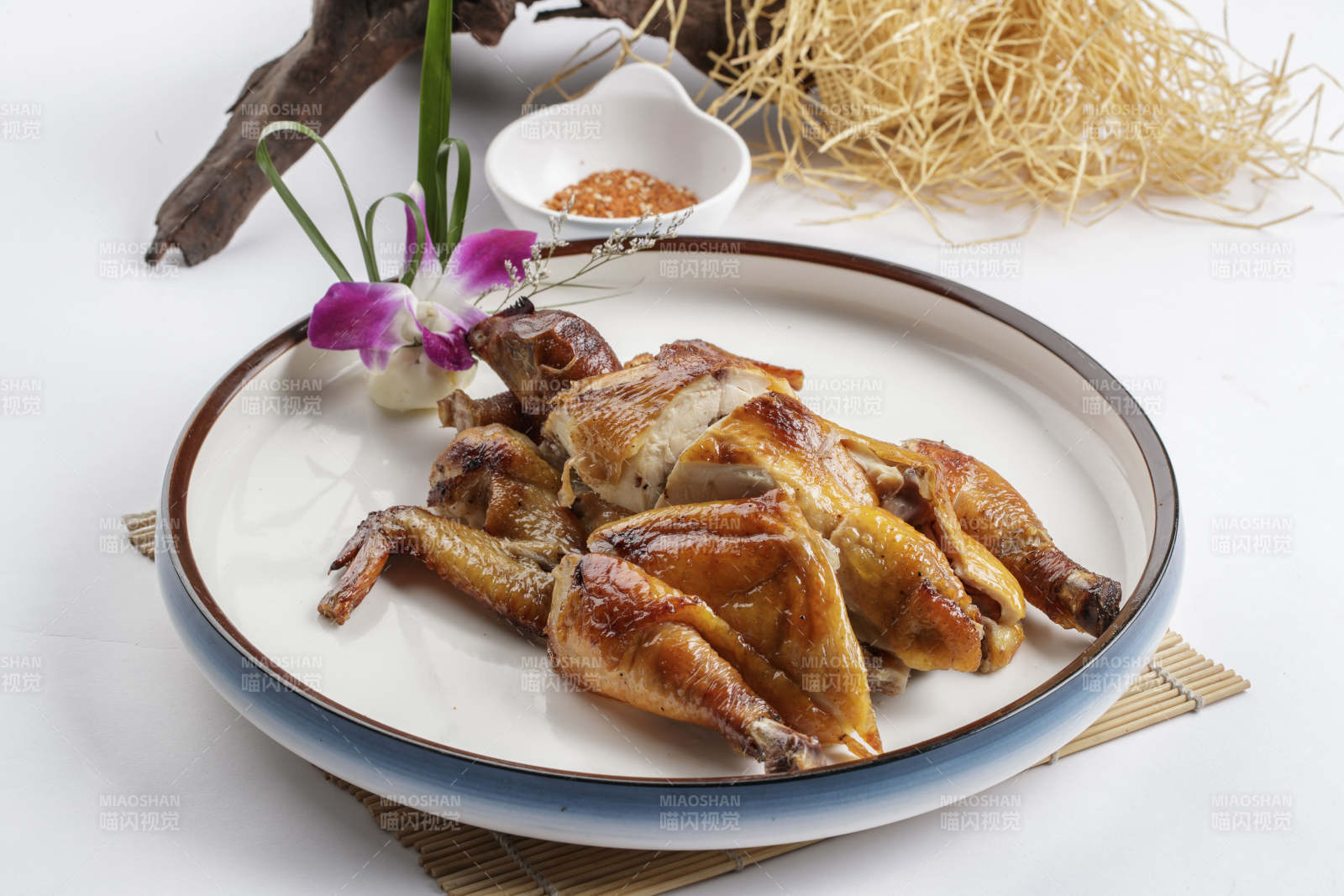 寿司帘上的圆瓷盘装的香酥脆皮鸡图片