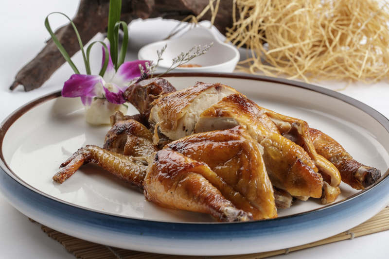 寿司帘上的圆瓷盘装的香酥脆皮鸡图片