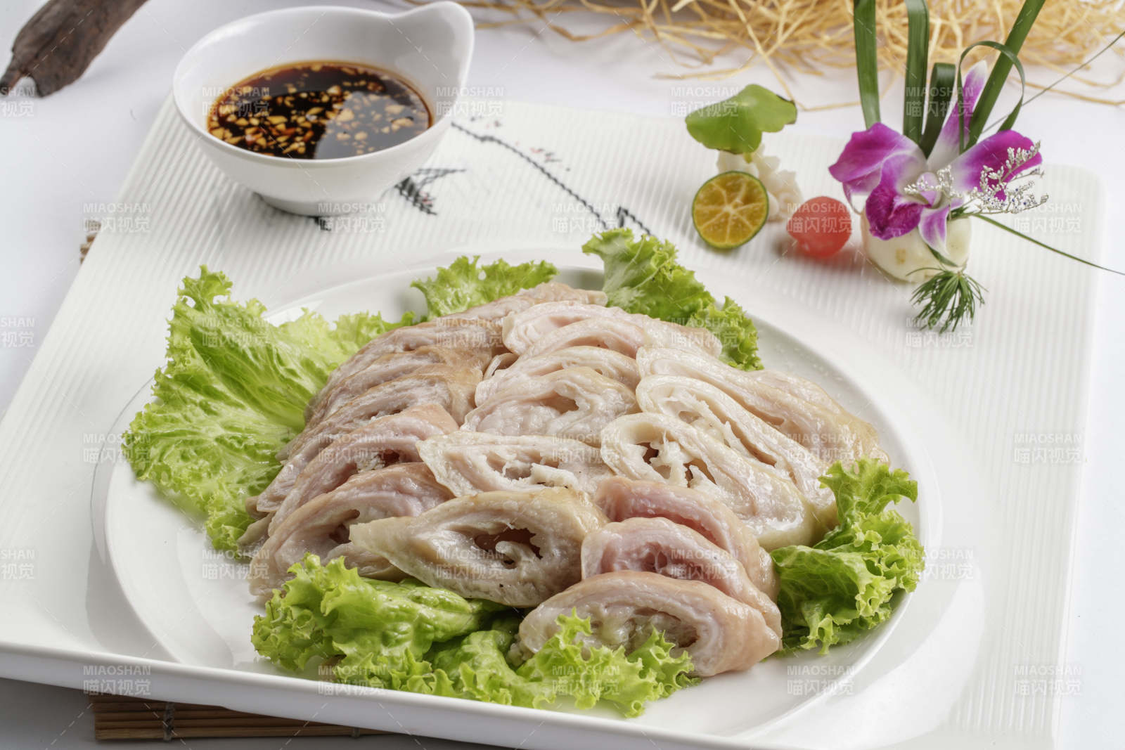 白色背景上的方瓷盘装的蘸汁马板肠图片