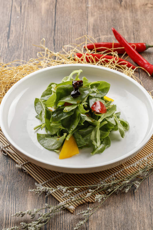 寿司帘上的圆瓷盘装的凉拌穿心莲图片