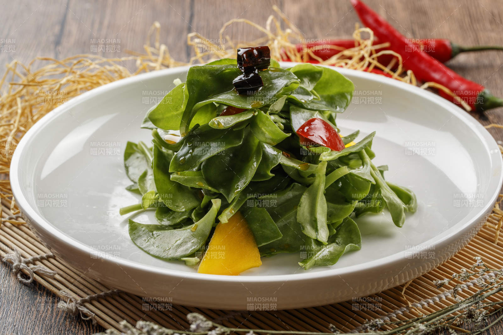 寿司帘上的圆瓷盘装的凉拌穿心莲图片