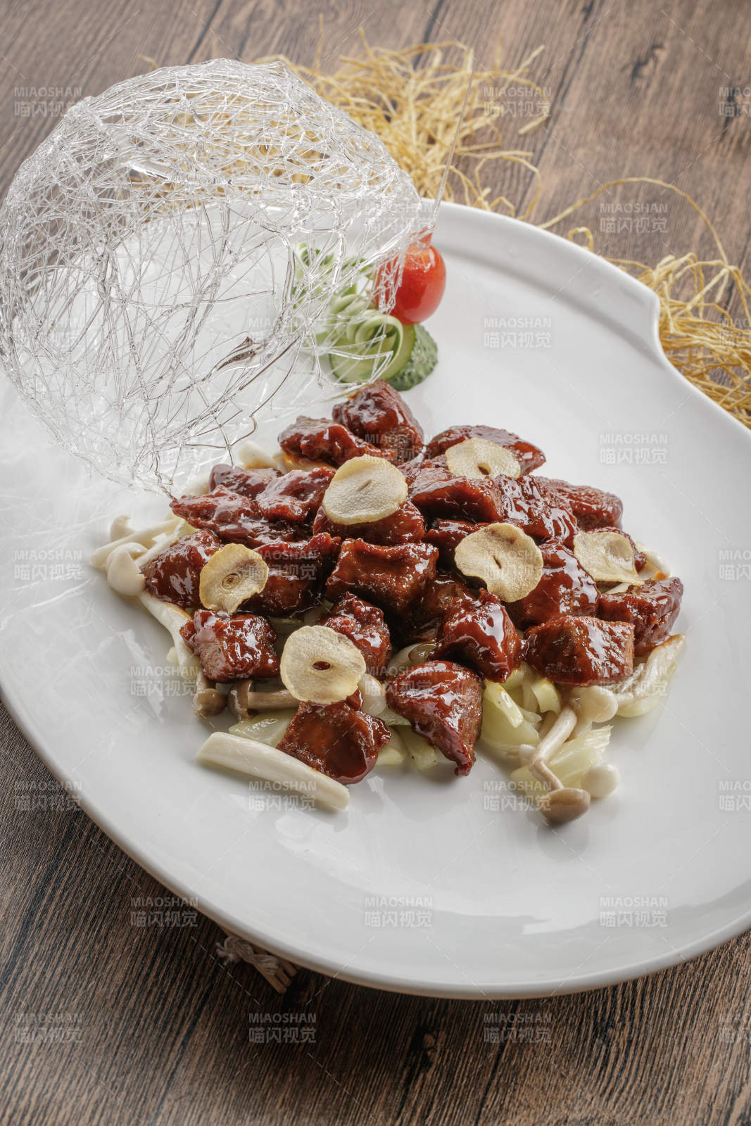 椭圆瓷盘装的蒜香海鲜菇黑椒酱牛仔粒图片