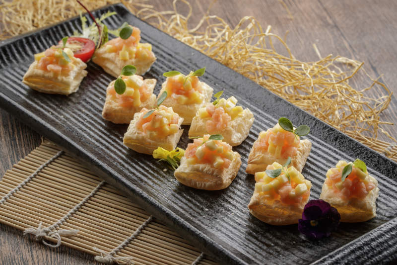 黑色长瓷盘装的芒果虾仁酥图片