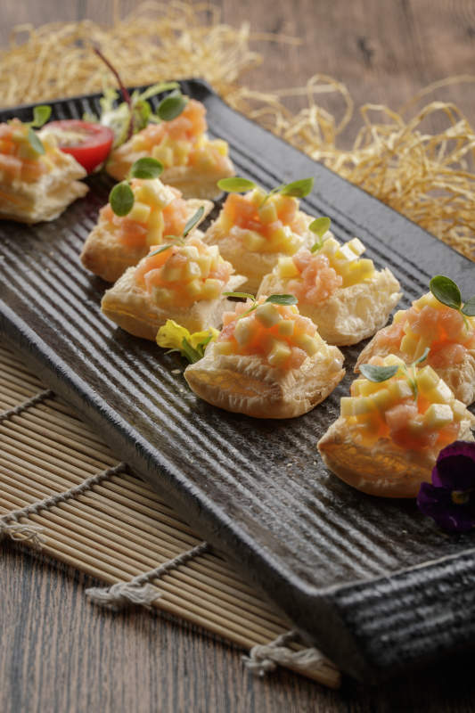 黑色长瓷盘装的芒果虾仁酥图片