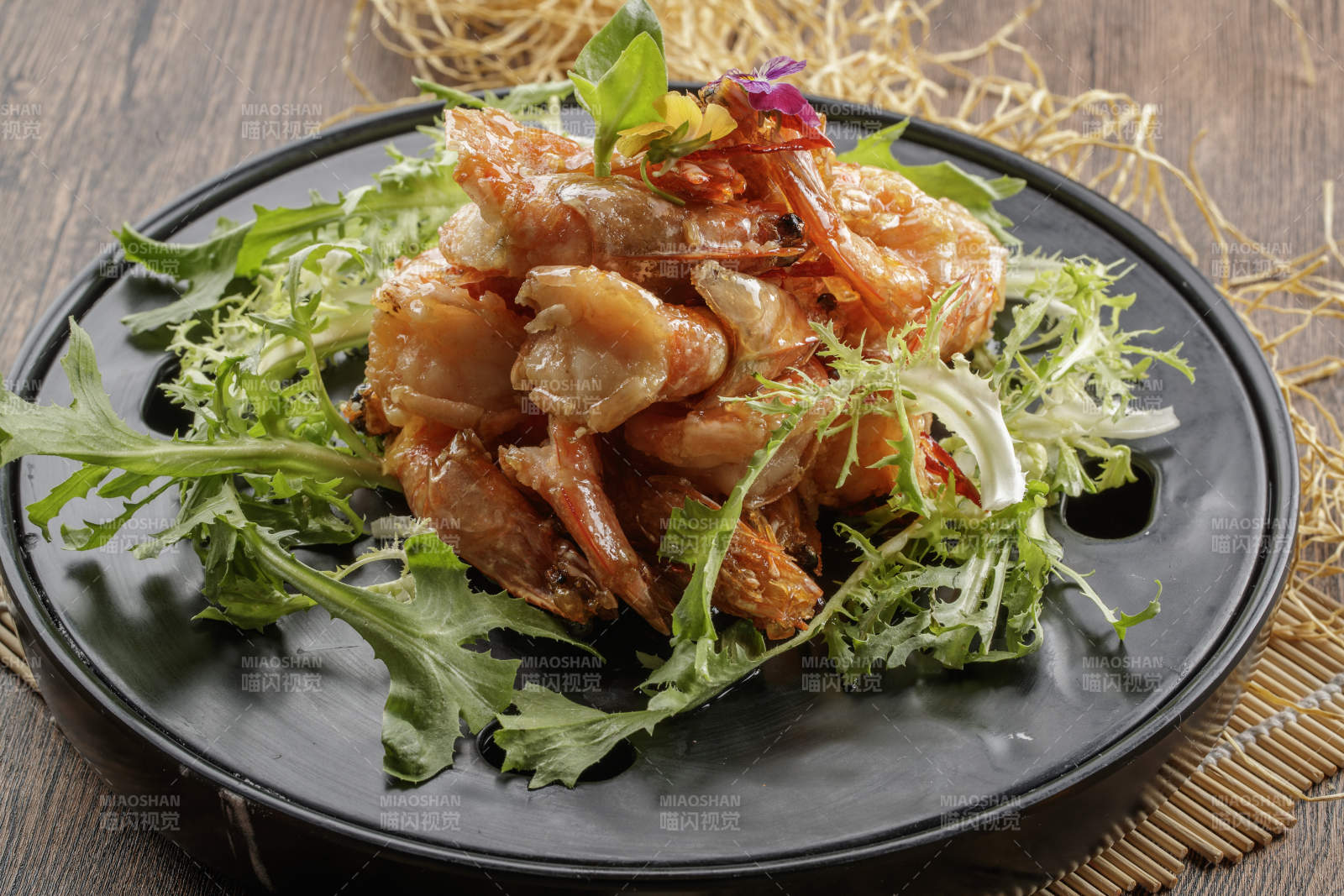 木质底纹上的黑石盘装的油炸大明虾图片