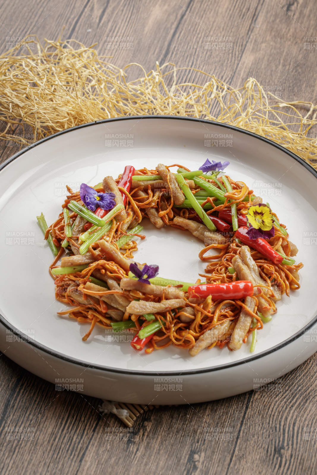 木质底纹上的圆瓷盘装的虫草花煸里脊丝图片