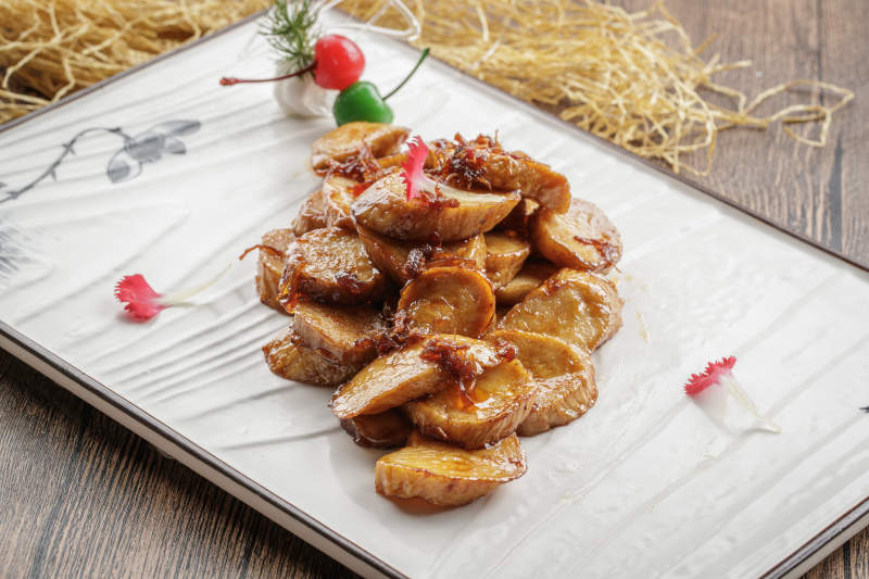 木质底纹上的长瓷盘装的香辣杏鲍菇图片