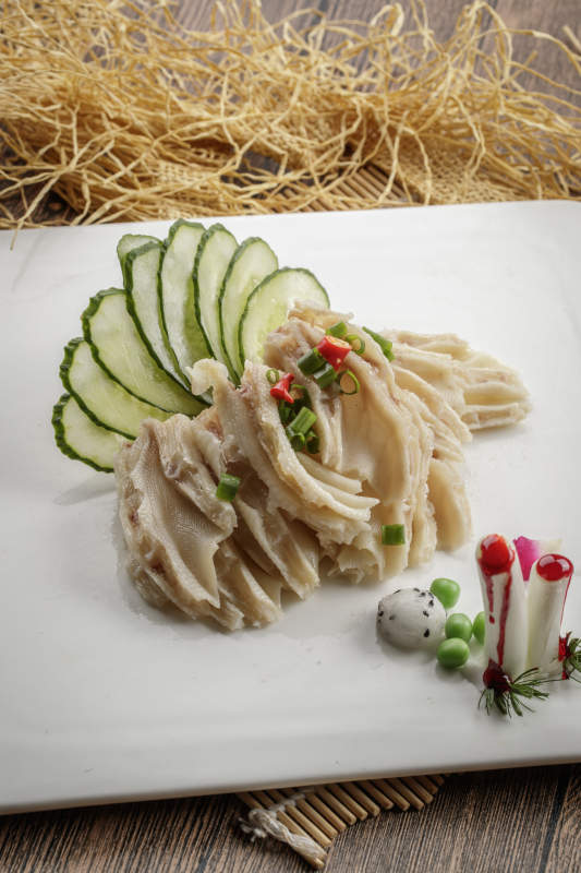 木质底纹上的方瓷盘装的脱骨鸭掌图片